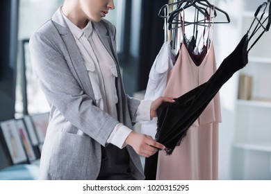 Cropped Shot Of Fashion Designer Examining Quality Of Clothing On Rack