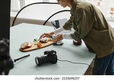 Cropped shot of female food photographer setting up gourmet bruschetta with props in studio, copy space - Powered by Shutterstock