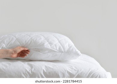 cropped shot of female hand close pillow with zipper on white background with copy space, fiberfill inside, hypoallergenic stuffing, comfort sleeping concept