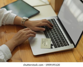 Cropped Shot Of Female Hand Holding Credit Card While Online Paying On Laptop 