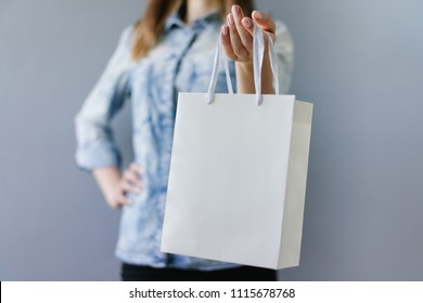 Cropped shot of female hands holding blank white paper bag in her hand. Front view, horizontal. Mock up, copy space for your text or logo. - Powered by Shutterstock