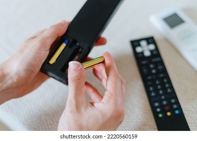 cropped shot of female hands insert new battery in tv remote control for watching television at home - Shutterstock ID 2220560159