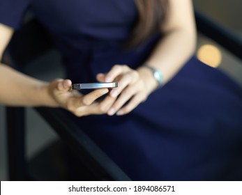 Cropped shot of female hands using smartphone while sitting on the chair in office room - Shutterstock ID 1894086571
