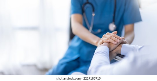 Cropped shot of a female nurse hold her senior patient's hand. Giving Support. Doctor helping old patient with Alzheimer's disease. Female carer holding hands of senior man - Shutterstock ID 2219183715