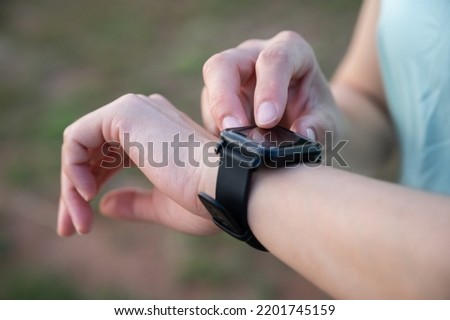 Cropped shot of female runner checking health status and fitness progress on her smart watch.