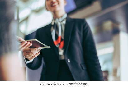 Cropped shot of flight attendant checking passport at airport. Ground attendant at departure gate checking passport of passenger. - Shutterstock ID 2022566291