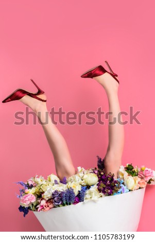 cropped shot of girl in high heeled shoes and skirt with beautiful flowers on pink, upside down view