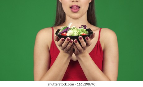 Cropped Shot Of A Gorgeous Sexy Woman Licking Lips Holding Bowl Of Salad