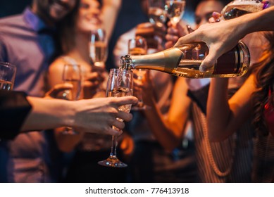 Cropped shot of a group of friends pouring champagne