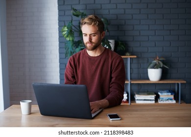 Cropped Shot Of A Handsome Young Man Working On His Laptop At Home