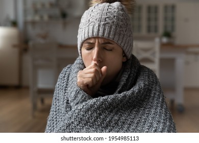 Cropped shot of ill millennial latina woman sit at home under warm blanket suffer from fever epidemic catarrh flu chronic bronchitis pneumonia. Sick young lady having health problems cough breath hard - Shutterstock ID 1954985113