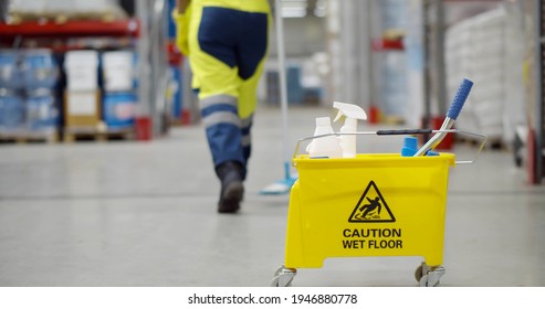 Cropped shot of janitor with bucket washing floor in warehouse focus on yellow cart with industrial worker cleaning floor with mop on storehouse background - Powered by Shutterstock