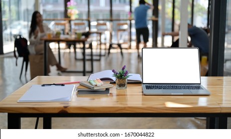 Cropped Shot Of Laptop, Notes And Office Supplies On A Wooden Desk In A Comfortable Shared Workspace.