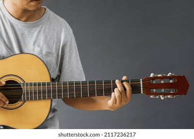 Cropped Shot Of Man Playing Guitar In G Major Chord Isolated On Gray Background With Copy Space