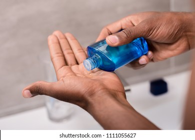 Cropped Shot Of Man Pouring After Shave Lotion Onto Hand