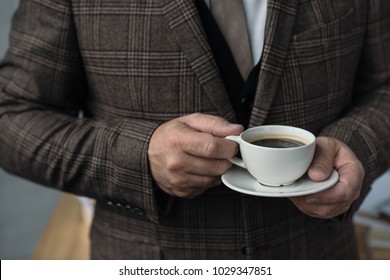 Cropped Shot Of Man In Tweed Suit With Cup Of Coffee