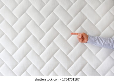 Cropped shot of man's hand pointing at copy space over white orthopedic mattress pattern. Hypoallergenic foam matress w/ proper spinal alingment & pressure point relief features. Background, close up.