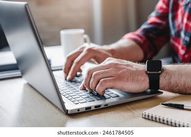 Cropped shot of man's hands using laptop at home office. Hands of adult contemporary office manager over laptop keypad during work over new business project by table - Powered by Shutterstock