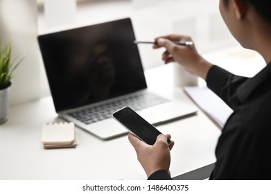 Cropped shot man's using mobile phone and analysis data.