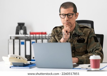 Cropped shot of a mid adult male soldier looking thoughtful while working on his laptop in the office