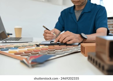 Cropped shot middle age man working on interior design project and choosing materials in studio - Powered by Shutterstock
