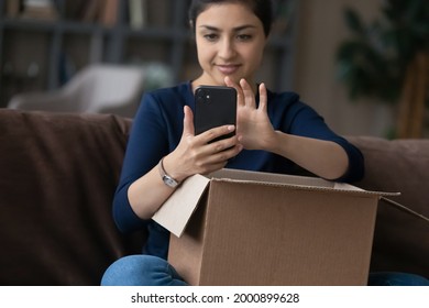 Cropped Shot Of Millennial Indian Woman Text Order On Phone To Courier Delivery Service To Send Gift For Friend Abroad By Mail. Happy Teen Female Blogger Shoot Unboxing Of Internet Purchase Using Cell