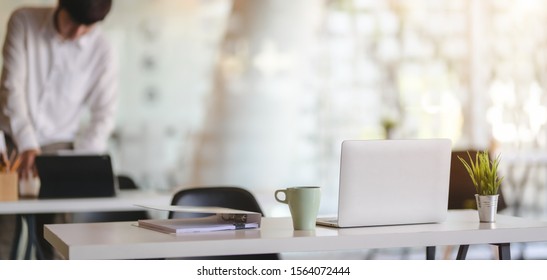 Cropped Shot Of Modern Office Room With Laptop Computer And Office Supplies With Office Environment In The Background