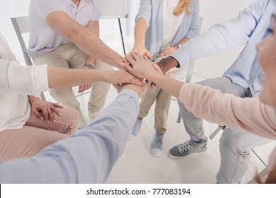 cropped shot of people stacking hands during group therapy