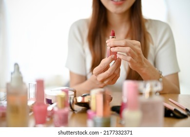 Cropped Shot, Professional Millennial Asian Female Beauty Blogger Holding, Showing Or Reviewing A Lipstick In Her Makeup Tutorial Video.