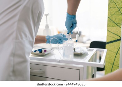 Cropped shot of professional unrecognizable female nurse preparing IV pole for patient in hospital. Closeup hands of medical worker preparing drop counter for procedure for sick patient in clinic. - Powered by Shutterstock