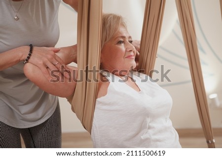 Cropped shot of a senior woman enjoying aerial yoga class with professional yoga instructor