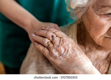 Aufschnitt einer älteren Frau, die Hände mit einer Krankenschwester hält