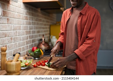 Cropped Shot Of Smiling Black Man Cutting Vegetables While Cooking In Cozy Kitchen, Copy Space