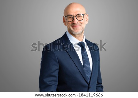 Cropped shot of smiling executive senior businessman wearing suit and tie while standing at isolated grey background. Copy space. 
