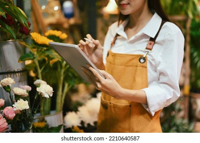 Cropped Shot Of Smiling Female Florist Checking, Receiving Online Order On Digital Tablet. Floristry, Business And Technology Concept