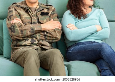 Aufschnitt eines Soldaten und seiner unerkennbaren Frau, die auf dem Sofa saßen und deren Arme nach einem Streit gekreuzt wurden