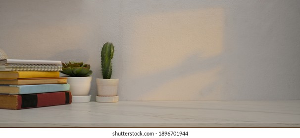 Cropped Shot Of Study Table In Home Office Room With Books, Plant Pots And Copy Space