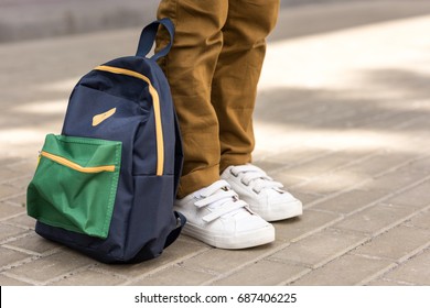 cropped shot of stylish schoolboy standing with backpack on street - Shutterstock ID 687406225