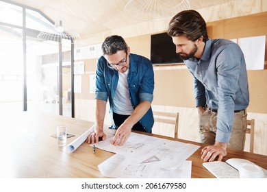 Cropped shot of two architects working on blueprints in their office - Shutterstock ID 2061679580