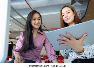 Cropped shot of two UI developers meeting on their project with paperwork and tablet on meeting table