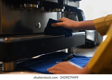 Cropped shot unrecognizable barista cleaning coffee machine - Powered by Shutterstock