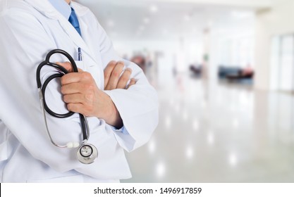 Cropped shot of an unrecognizable male doctor standing with his arms folded inside of a hospital during the day and copy space