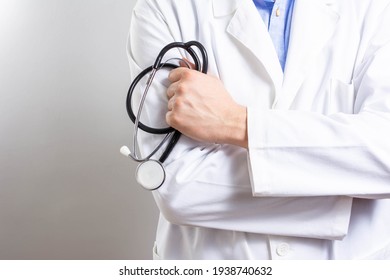 Cropped shot of an unrecognizable male doctor standing with his arms folded isolated on white background. Copy space. medicine doctor holding stethoscope in his hand wearing medical gown standing 