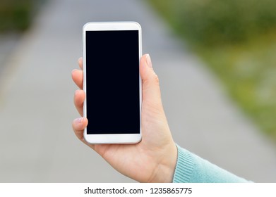 Cropped shot of an unrecognizable young woman using a smartphone outside