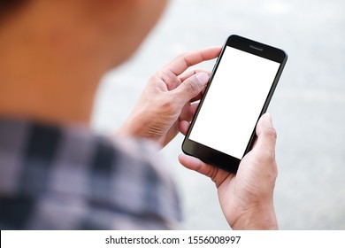 Cropped shot view of man hands holding smart phone with blank copy space screen for your text message or information content, female reading text message on cell telephone during in urban setting.  - Shutterstock ID 1556008997