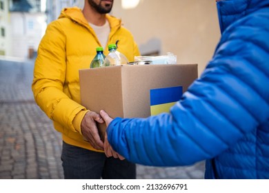 Cropped shot of volunteers collecting boxes with Humanitarian aid for Ukrainian refugees in street - Shutterstock ID 2132696791