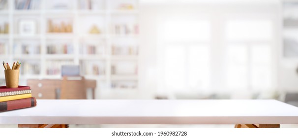 Cropped shot of white table with books, stationery and copy space in blurred study room - Shutterstock ID 1960982728