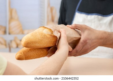 Foto recortada de una mujer comprando baguettes recién hechos o pan en una cafetería