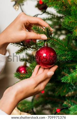 cropped shot of woman decorating christmas tree