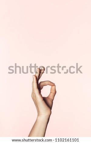 cropped shot of woman doing ok gesture by hand isolated on pink background